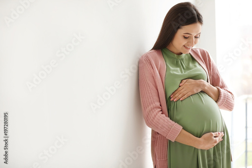 Young pregnant woman in casual clothes indoors photo