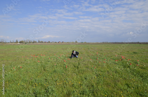 A man in a jacket on a field of tulips. Glade with tulips