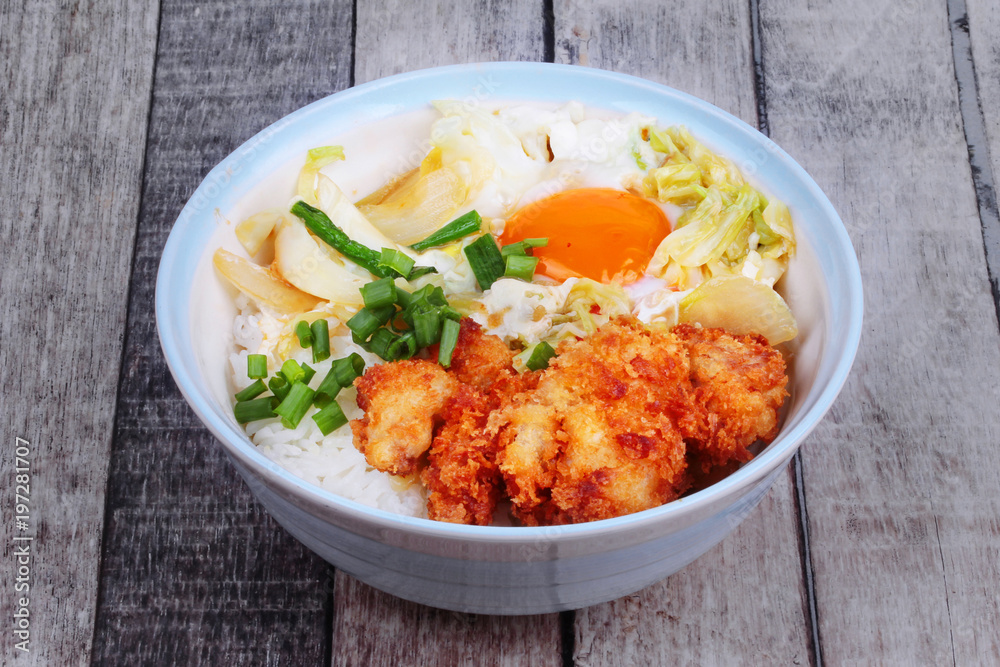 Jasmine rice with deep fried Chicken topped soft boil eggs and fried pork with mixed vegetablein Japanese style. Jasmine rice with deep fried Chicken topped soft boil eggs and fried pork with mixed vegetablein Japanese style.