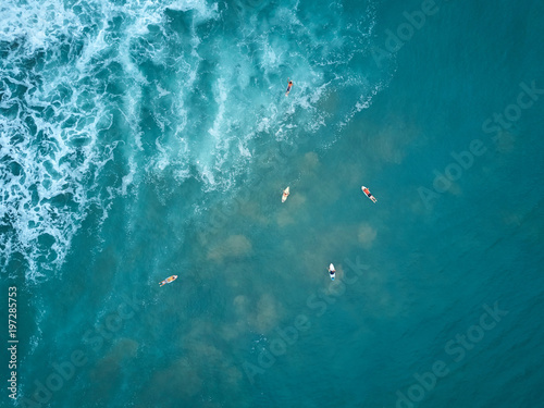 Surfers swim to big wave