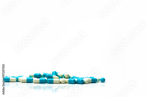 Pile of blue and white capsules pills isolated on white background with shadows and copy space for text. Global healthcare concept. photo