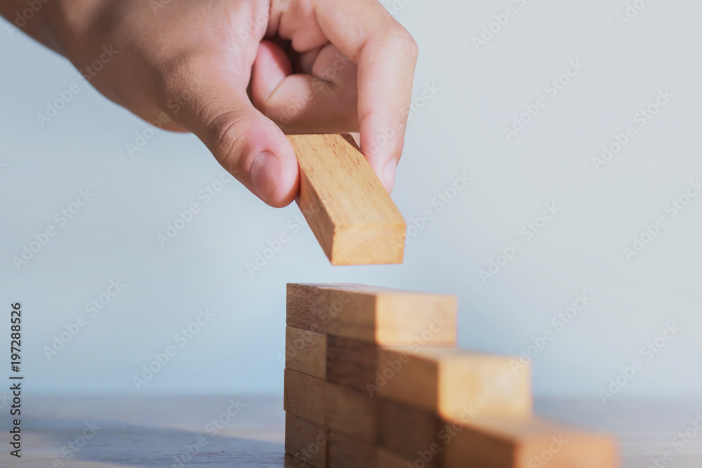 hand stack woods block step on table. business development concept