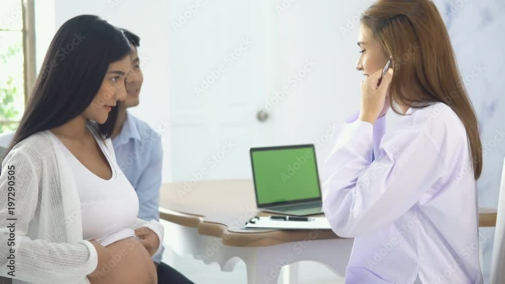 Young female doctor talked with couple during the pregnancy check-up Young female doctor talked with couple during the pregnancy check-up