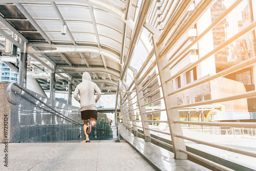 Runner jogging training and doing workout exercising power running outdoors in city..A handsome young man running in the city at morning..Sportsman fitness jog workout wellness concept © Hathaichanok