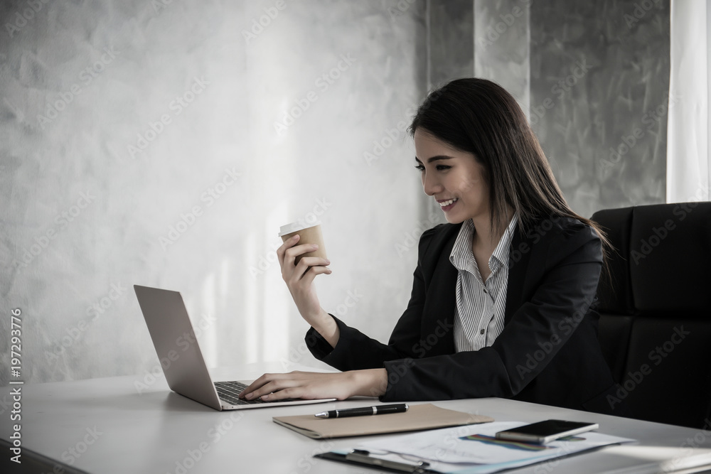 Young businesswoman smiling working on laptop in the office Young businesswoman smiling working on laptop in the office