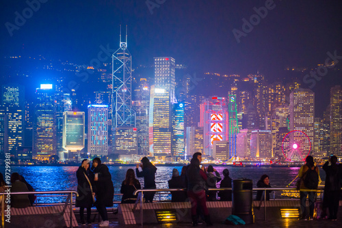 Tourists relaxing around Victoria Harbor at night time in Hong Kong