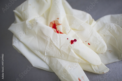 medical gloves stained with blood on the medical table
