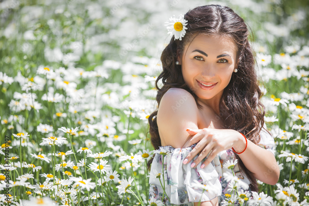 Pretty young woman in the chamomile field. Beautiful girl with flowers Pretty young woman in the chamomile field. Beautiful girl with flowers
