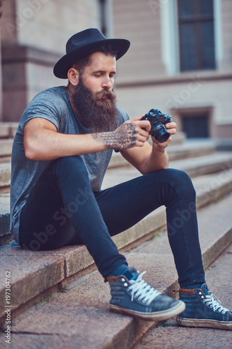 A handsome hipster male with a stylish beard and tattoo on his a