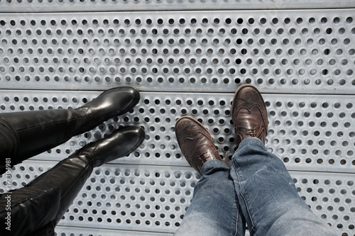 legs of man and woman on steel surface