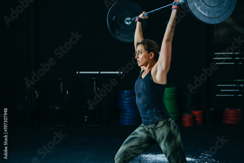 Woman does jerk with barbell © click_and_photo