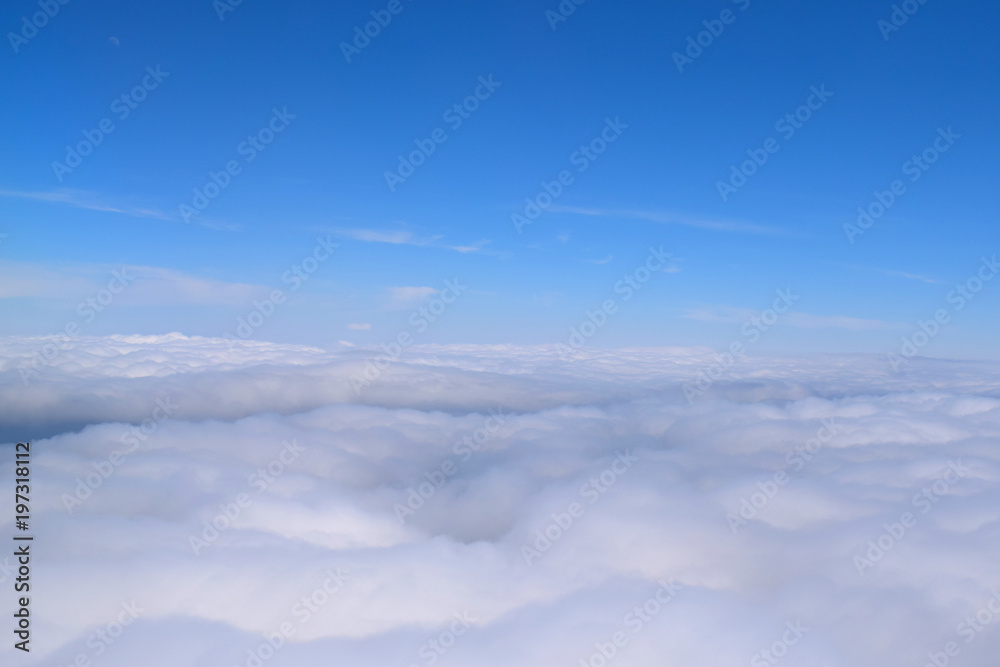 Cloud formations from above and below in a blue sky, photographed from the ground and from an airplane