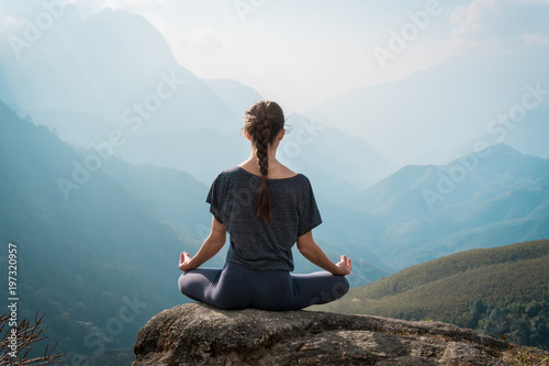 Woman meditates in yoga asana Padmasana photo
