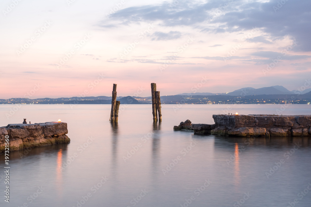 Naklejka premium punta san idillio lago di garda al tramonto molo porto