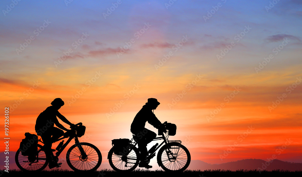 Fototapeta premium Silhouette man and bike relaxing on blurry sunrise background