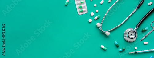 Pills and medical equiupments on green banner background photo