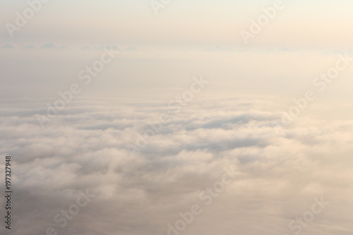 View of clouds from plane in beams of the sunset sun
