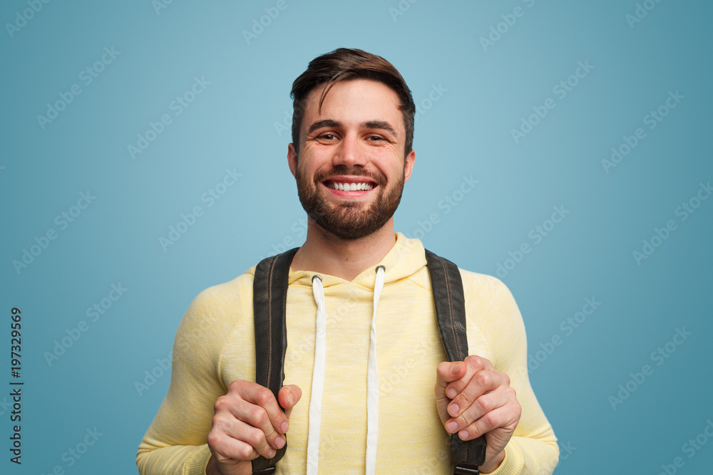 Excited laughing male student on blue - obrazy, fototapety, plakaty 