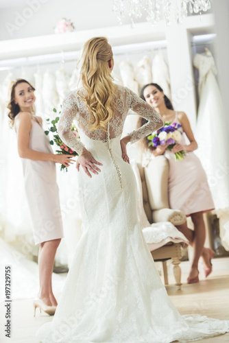 Happy women in wedding dresses in wedding fashion shop