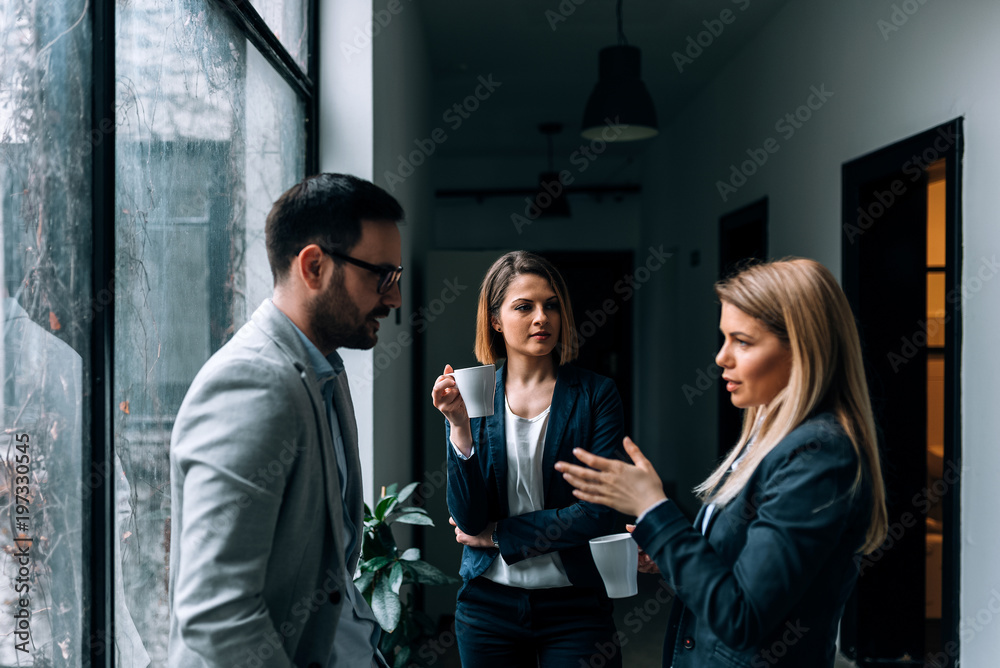 Business team drinking coffee and relaxing at work.