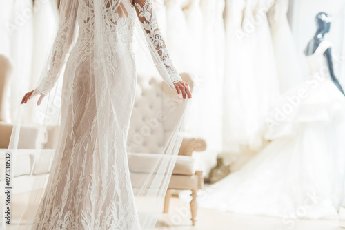 Cropped view of bride in lace dress in wedding salon
