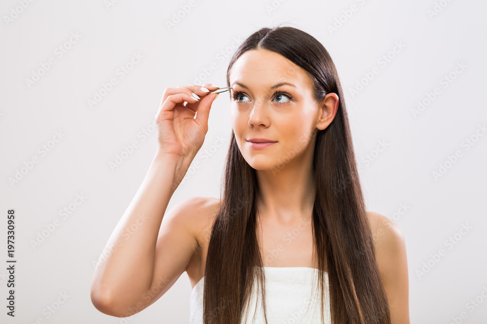 Image of beautiful brunette woman plucking eyebrows. Image of beautiful brunette woman plucking eyebrows.