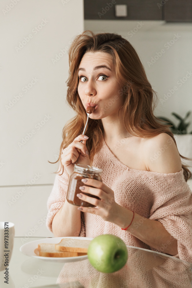 Portrait of a pleased young woman having tasty breakfast Portrait of a pleased young woman having tasty breakfast