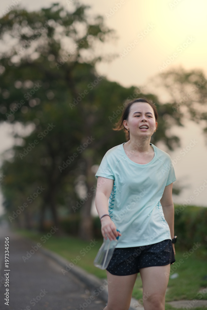 tired runner run with water bottle in hand on sun flare on background tired runner run with water bottle in hand on sun flare on background