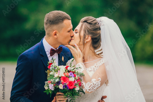 Sensual portrait of a young couple. Wedding photo outdoor. newlyweds bride and groom at a wedding in nature green forest are kissing photo portrait.