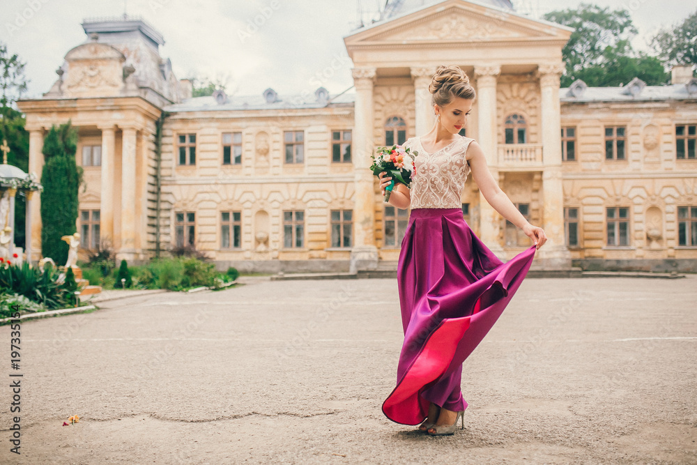 Portrait of a beautiful bridesmaid posing with bride's wedding bouquet near old castle. Amaizing wedding day. Portrait of a beautiful bridesmaid posing with bride's wedding bouquet near old castle. Amaizing wedding day.