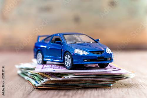 blue toy car with euro bills on desk