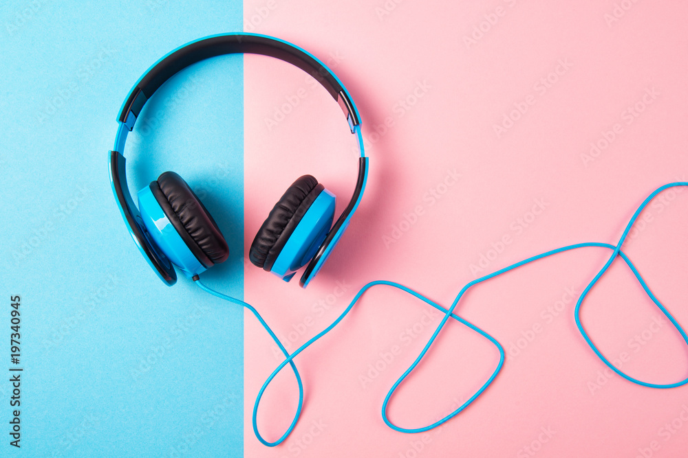 Headphones on blue and pink background, top view Headphones on blue and pink background, top view