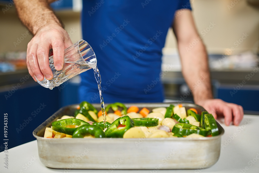 Man pouring water over a tray