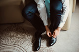Grooms morning preparation, handsome groom getting dressed and preparing for the wedding, wearing a shoes
