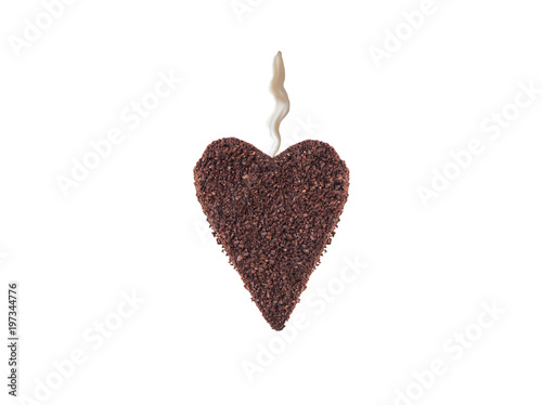 A huge cookie from ground coffee in the form of a heart with stream of milk on colorful background 