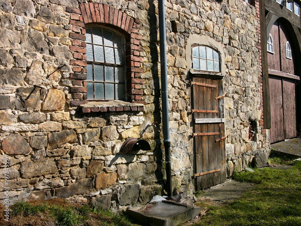 Wunderschönes altes Mauerwerk aus Bruchstein und Naturstein eines alten Bauernhaus mit Holztür