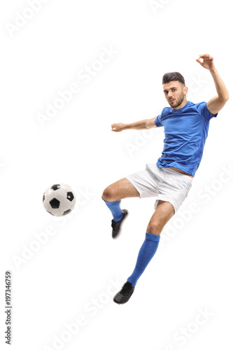 Male soccer player kicking a football in mid-air