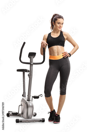 Fitness woman leaning on a stationary bike