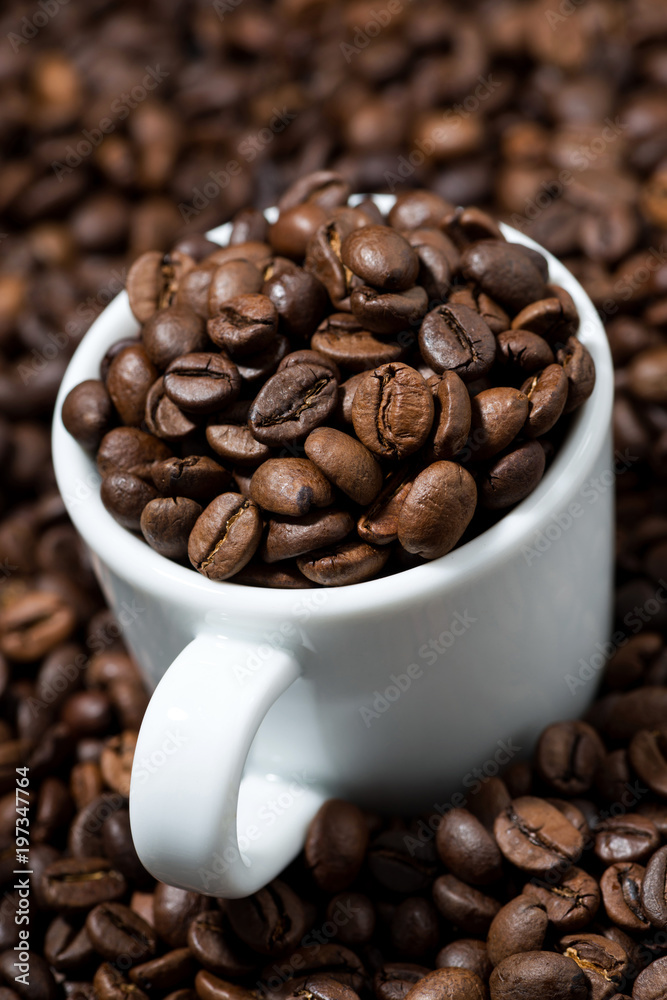 white cup in coffee beans, concept photo, vertical closeup white cup in coffee beans, concept photo, vertical closeup
