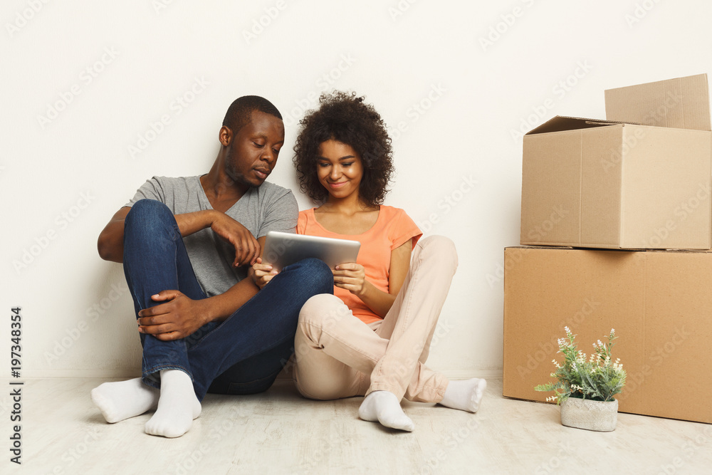 Black couple sitting on floor at new apartment Black couple sitting on floor at new apartment