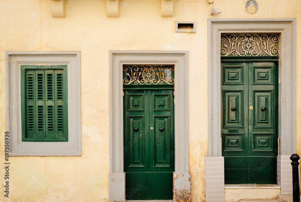 Facade of traditional maltese house in Valletta with beautiful green doors, Malta