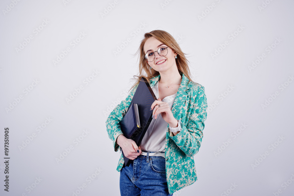 Stylish blonde girl in jacket and jeans at glasses with notebook diary and laptop at hands against white background on studio. Stylish blonde girl in jacket and jeans at glasses with notebook diary and laptop at hands against white background on studio.