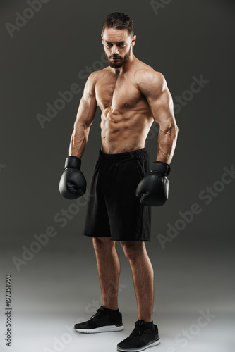 Full length portrait of a confident shirtless muscular sportsman