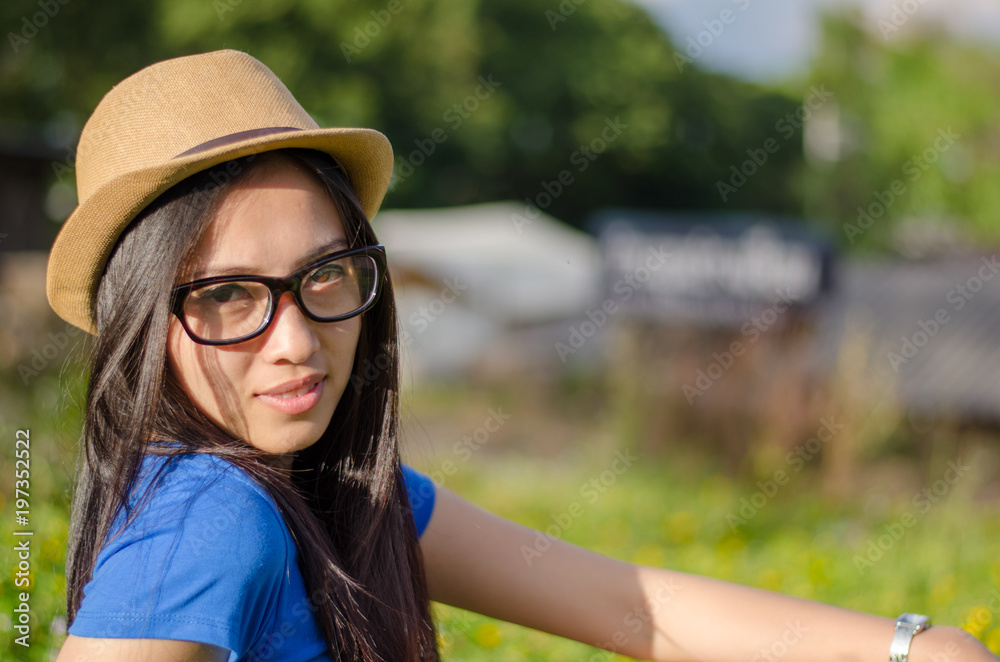 Happy Asians female in cowgirl hat and  wear glasses looking at camera with toothy smile