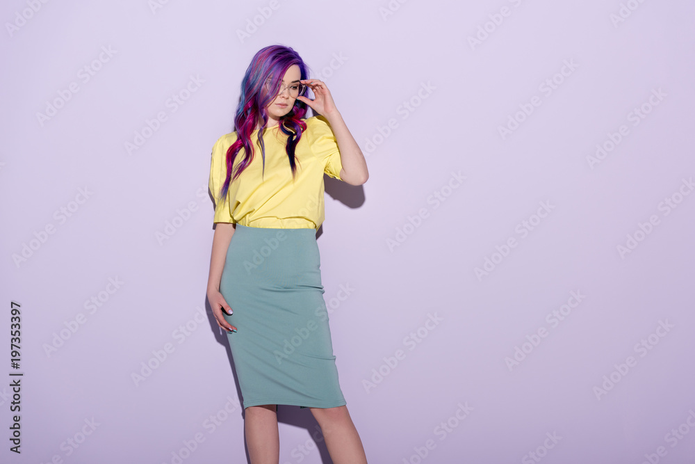 beautiful young woman with colorful hair and stylish eyeglasses on pink