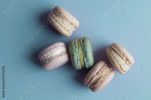 Composition of delicious macaroons on blue table, sweet dessert