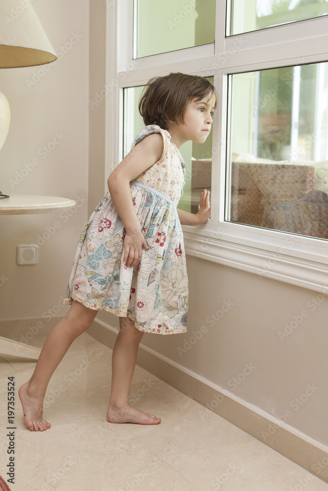 little girl looking out through a window little girl looking out through a window