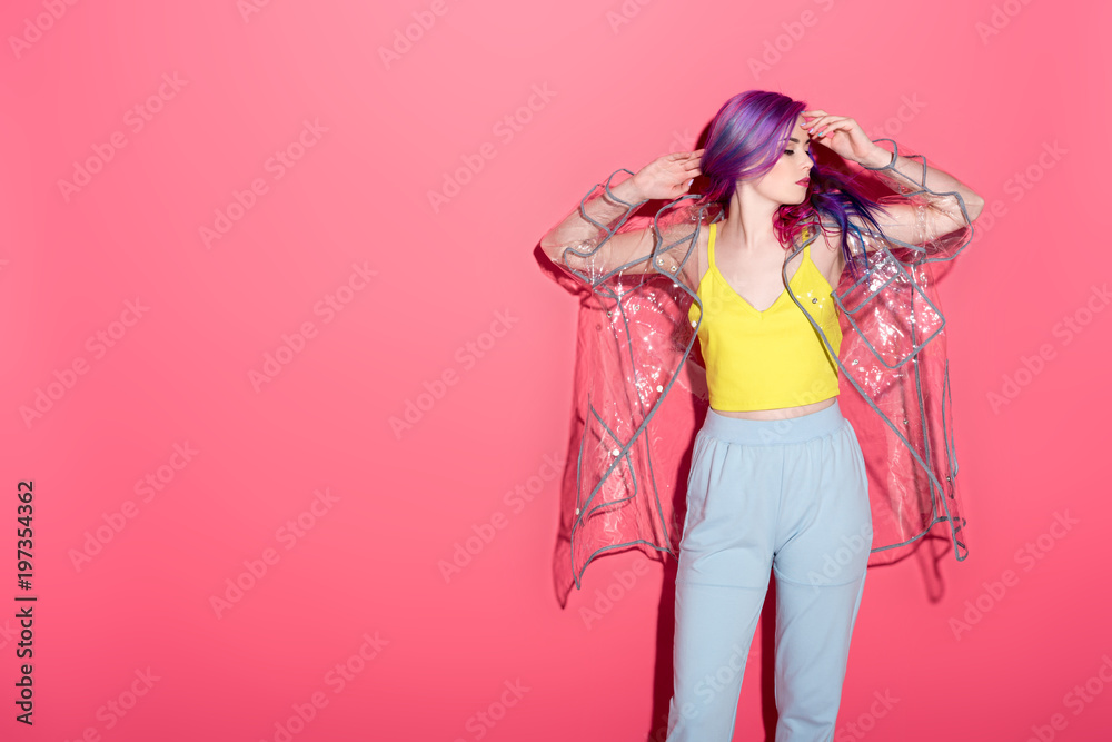 fashionable young woman in transparent raincoat on red fashionable young woman in transparent raincoat on red