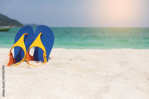 Beach sandals on the sandy sea coast, summer concept holiday and vacation concept. Tropical sea