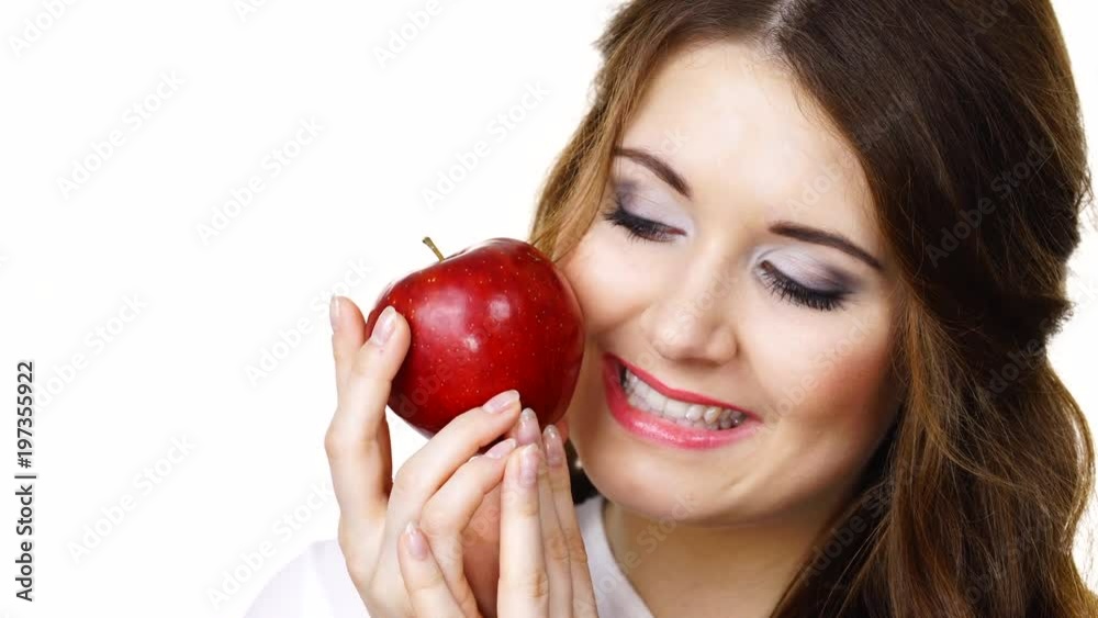 Woman holding red apple fruit in hand close to face, isolated on white. Healthy eating, high fibre diet concept. Woman holding red apple fruit in hand close to face, isolated on white. Healthy eating, high fibre diet concept.
